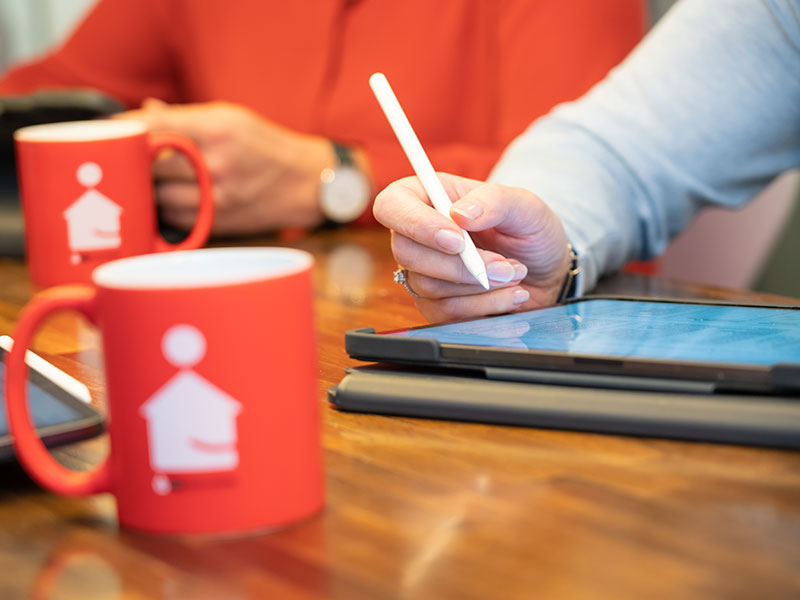 Eine Frau hält einen weißen Stift für ein Tablet