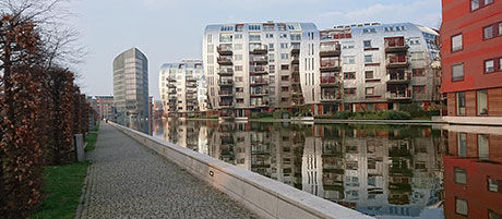 Mehrere Wohnungsblocks vor einem Teich